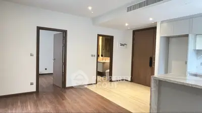 Spacious modern apartment interior with open layout and wooden flooring.