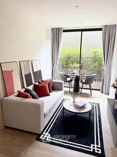 Stylish modern living room with elegant decor and natural light, featuring a cozy sofa and chic dining area.
