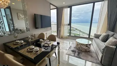 Luxurious living room with stunning ocean view, elegant dining setup, and modern decor in high-rise apartment.