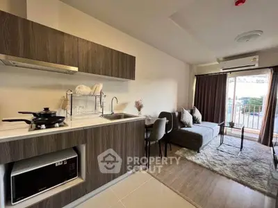 Modern open-layout kitchen and living room with stylish decor and balcony view.