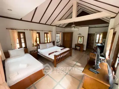 Spacious bedroom with vaulted ceiling and elegant wooden furniture, perfect for a cozy retreat.
