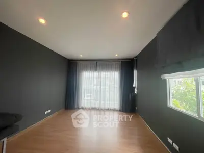 Spacious empty room with large windows and wooden flooring, ideal for customization.