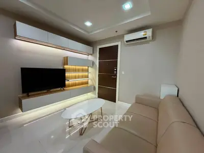 Modern living room with sleek furniture and wall-mounted TV in a stylish apartment.