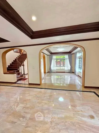 Spacious open living area with elegant marble flooring and large windows.