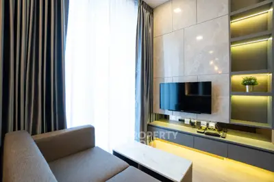 Modern living room with sleek design, featuring a wall-mounted TV and elegant lighting.