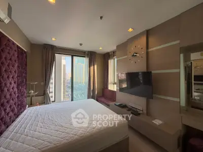 Luxurious bedroom with city view, modern decor, and wall-mounted TV in high-rise apartment.