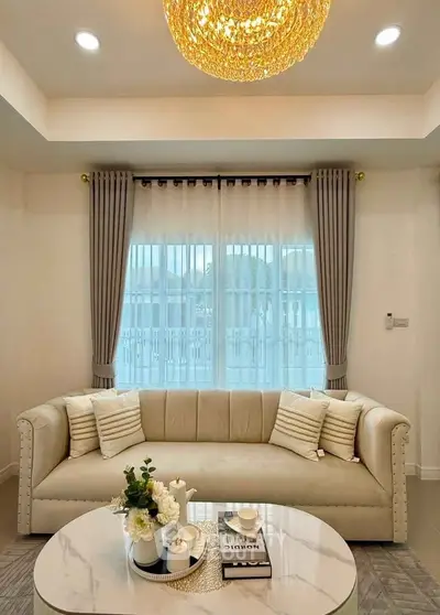 Elegant living room with plush sofa, chic coffee table, and stylish chandelier.