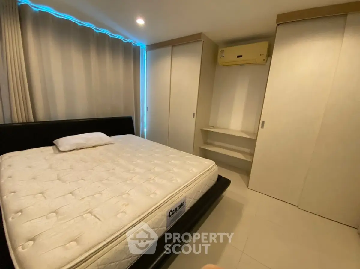 Spacious bedroom with modern design, featuring a comfortable bed and ample closet space.
