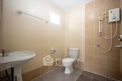 Modern bathroom with beige tiles and wall-mounted shower unit.