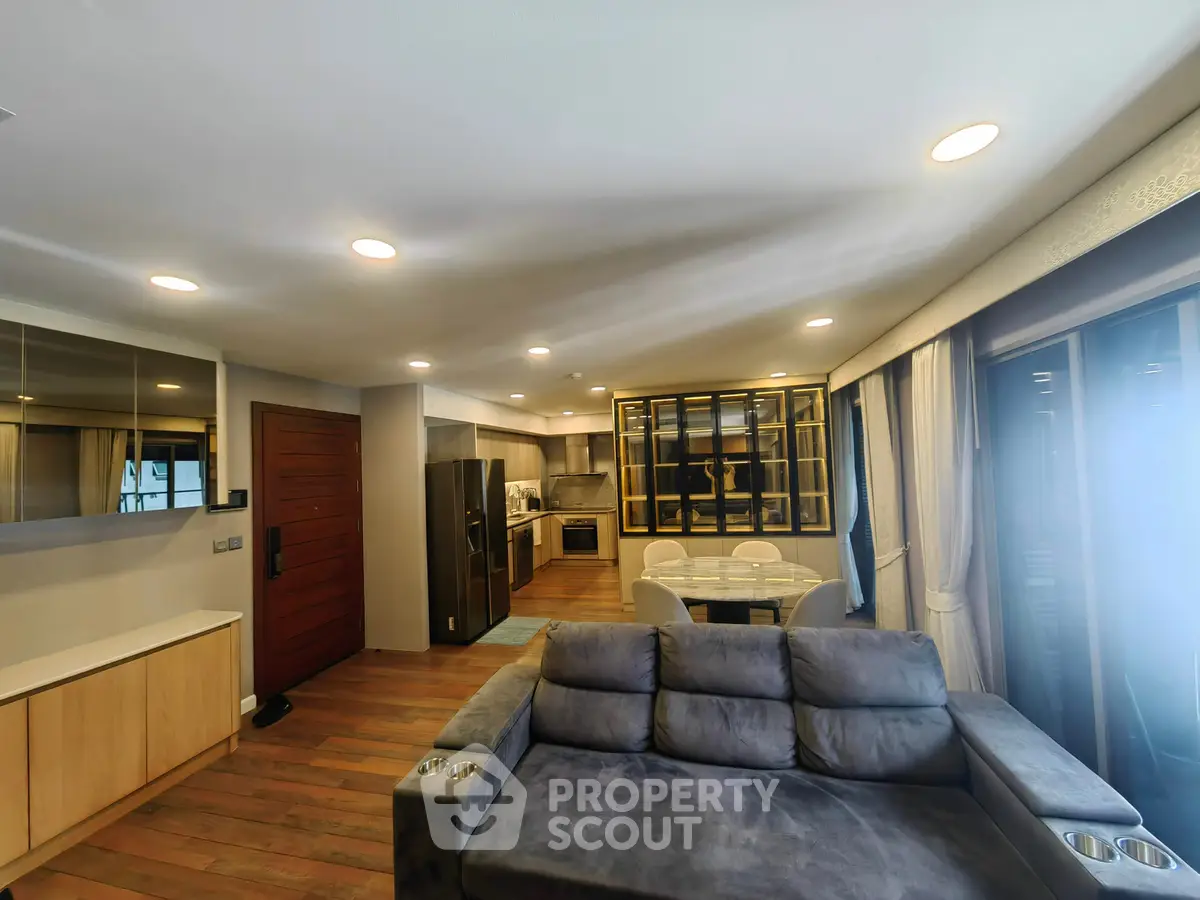 Modern open-plan living room with sleek kitchen and cozy seating area, perfect for entertaining.