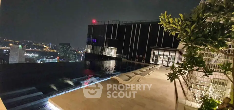 Luxurious rooftop infinity pool with stunning city skyline view at night.