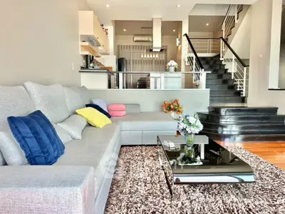 Spacious modern living room with stylish decor and open kitchen layout.