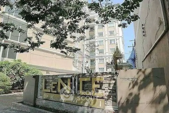 Modern apartment building with lush greenery and stylish entrance sign.