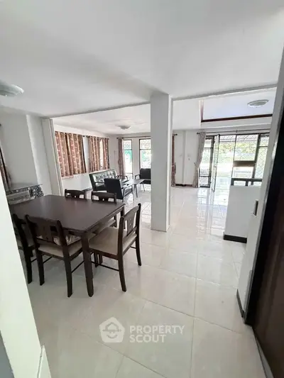 Spacious open-plan living and dining area with natural light and modern furnishings.