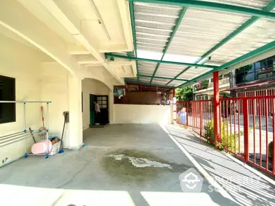 Spacious covered parking area with red fence and ample natural light