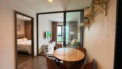 Modern apartment interior with dining area and bedroom view, featuring stylish decor and natural light.