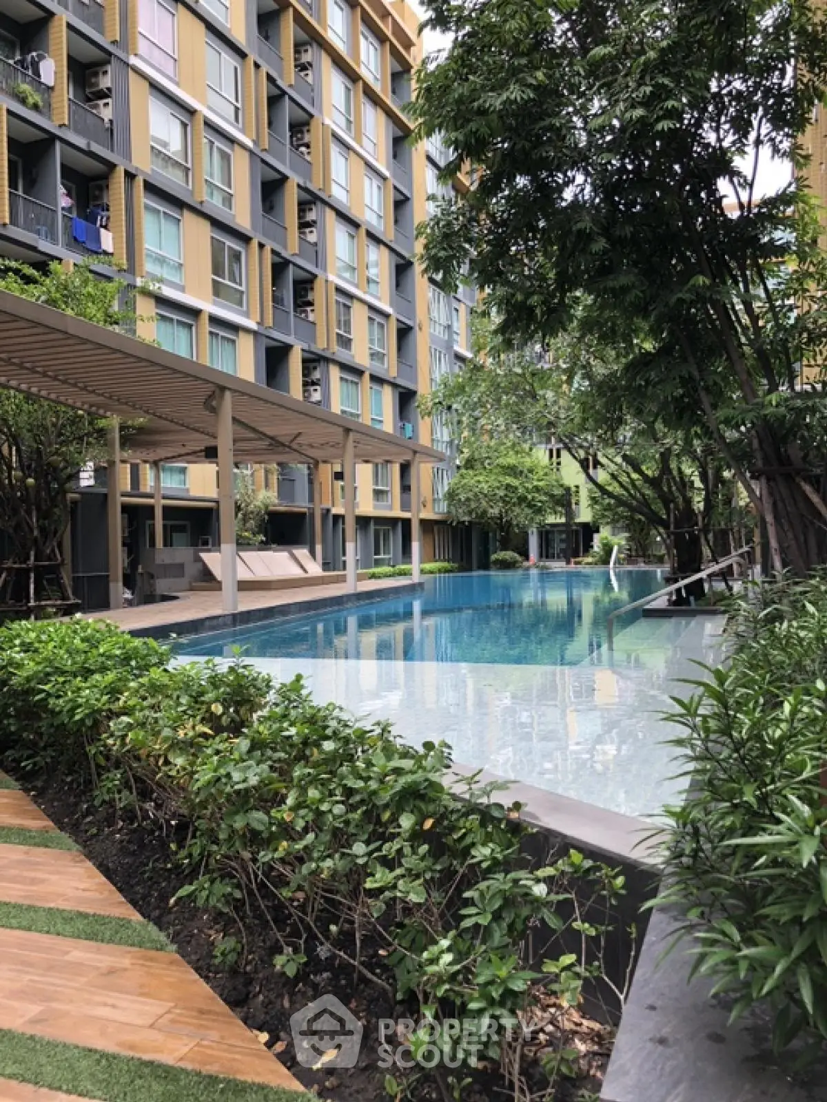 Modern apartment complex with luxurious pool and lush greenery
