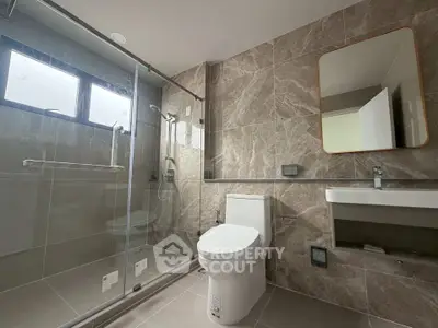 Modern bathroom with glass shower and sleek fixtures in a contemporary home.