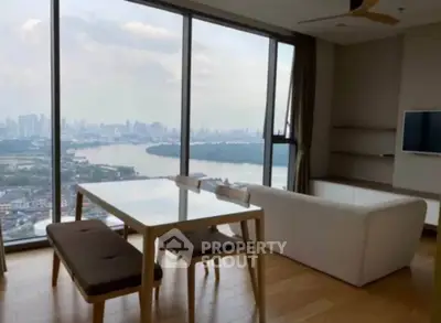 Stunning living room with panoramic city and river views, featuring modern furniture and floor-to-ceiling windows.