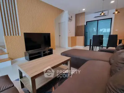 Modern living room with stylish decor and open layout, featuring a cozy seating area and sleek dining space.