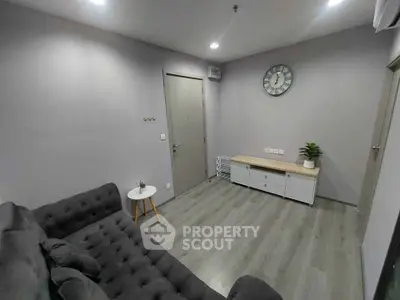 Modern living room with stylish gray sofa and wall clock, perfect for cozy relaxation.