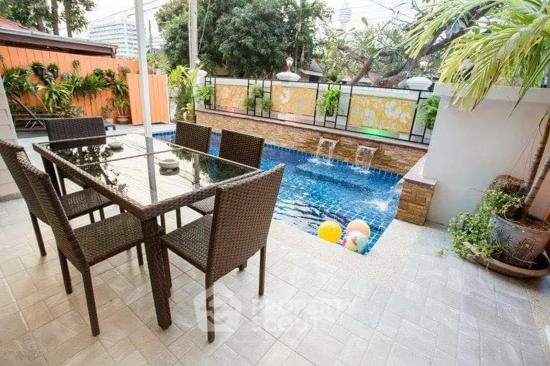 Charming outdoor patio with pool and dining set, perfect for entertaining.