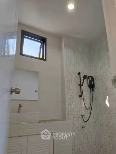 Modern bathroom with sleek shower and natural light from window