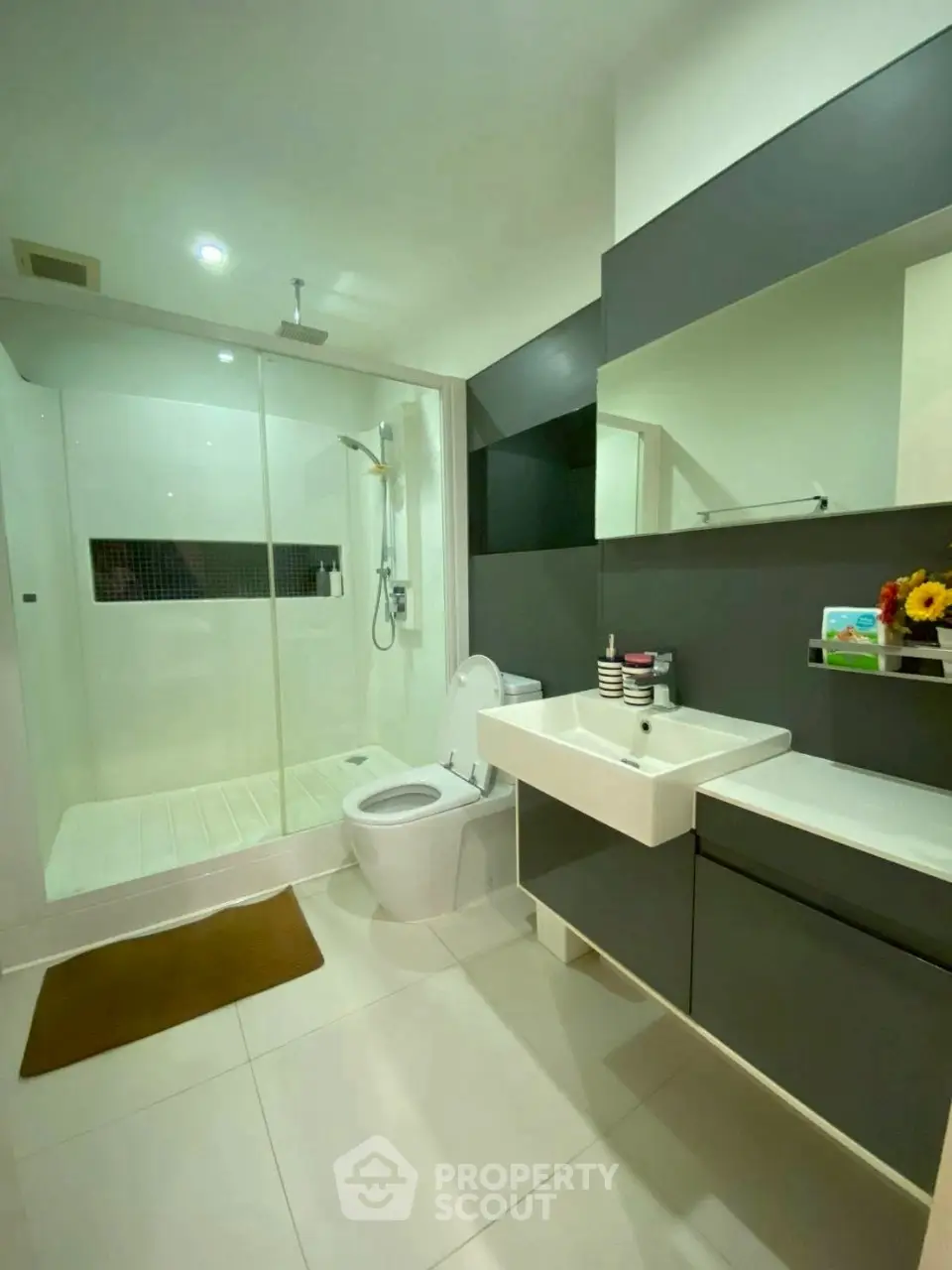 Modern bathroom with sleek design, featuring a glass shower enclosure and stylish vanity.