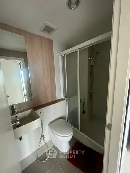Modern bathroom with shower and sleek fixtures in contemporary apartment.
