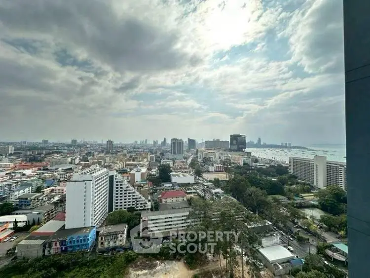 Stunning cityscape view from high-rise building with ocean in the distance.