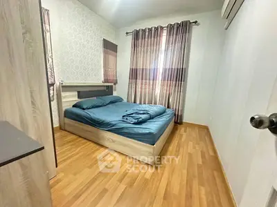 Cozy bedroom with wooden flooring and elegant curtains, perfect for restful nights.
