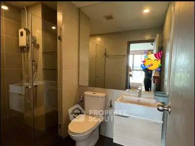 Modern bathroom with glass shower and sleek fixtures in a contemporary apartment.