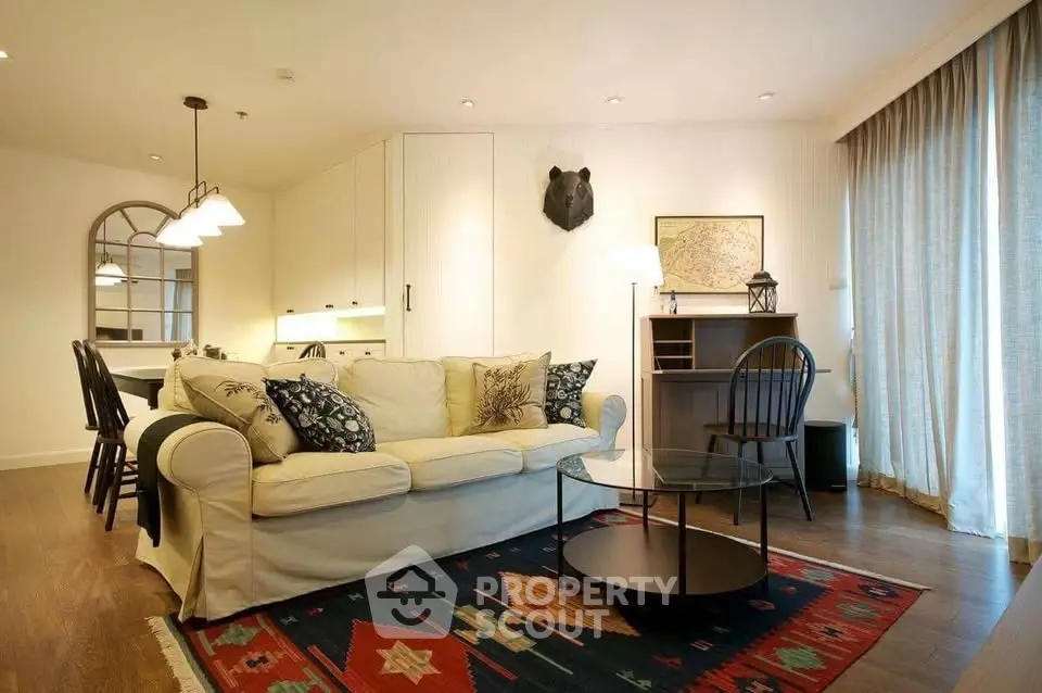 Charming living room with cozy sofa, stylish decor, and warm lighting in modern apartment.