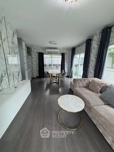 Spacious living room with elegant marble walls and modern furniture, perfect for stylish living.