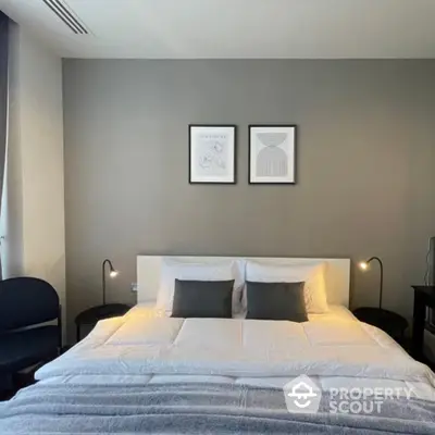 Elegant bedroom with a large comfortable bed, stylish wall art, and modern bedside lighting, creating a serene and sophisticated sleeping space.