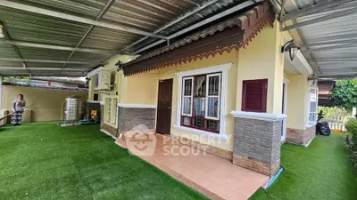 Charming single-story home with covered patio and lush artificial grass lawn, perfect for outdoor relaxation.