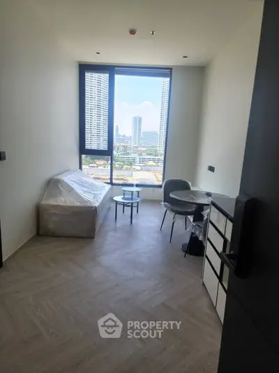 Modern living room with city view, featuring minimalist furniture and large windows.