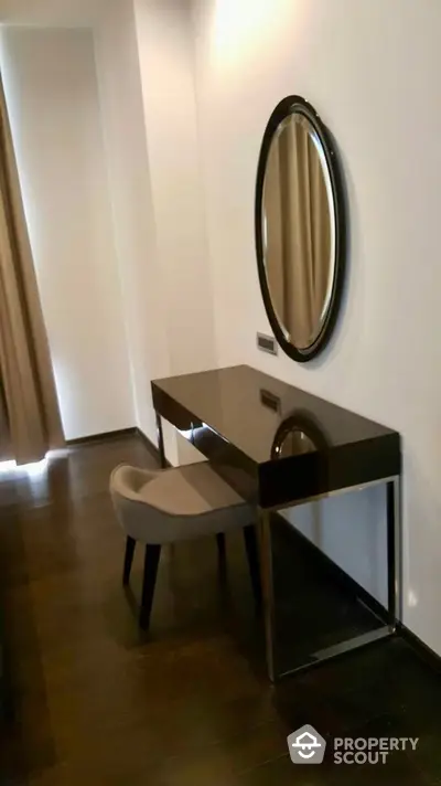 Elegant study nook with sleek desk and round mirror in modern apartment