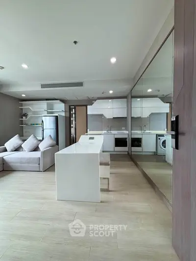 Modern open-layout kitchen and living room with sleek design and ample natural light.