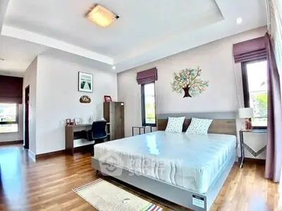 Spacious modern bedroom with wooden flooring and stylish decor