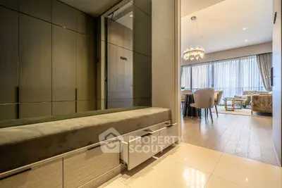 Luxurious modern apartment entrance leading to elegant living room with chandelier.