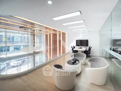 Modern office space with glass walls, sleek furniture, and natural light.