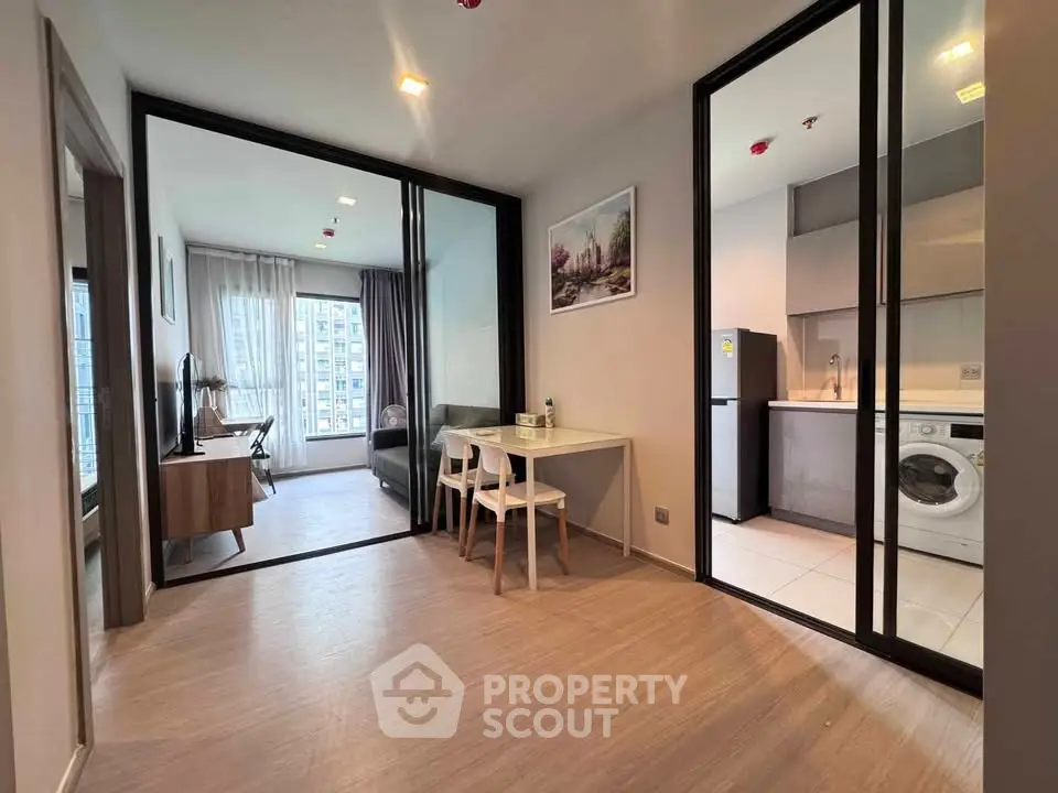 Modern apartment interior with open layout, featuring a stylish living area and kitchen with appliances.