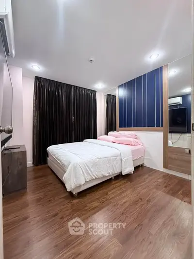 Modern bedroom with wooden flooring and stylish decor in a cozy apartment.