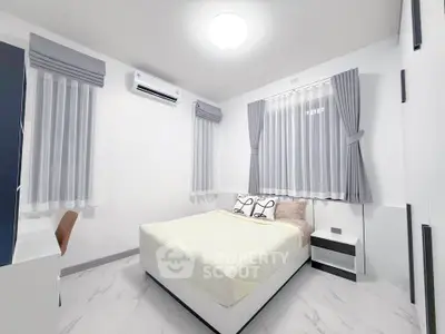 Modern minimalist bedroom with sleek design and ample natural light.