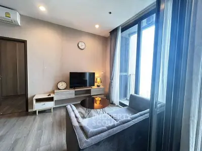 Modern living room with sleek furniture and balcony view in stylish apartment.