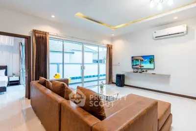Spacious modern living room with pool view and brown leather sofa
