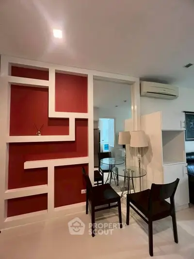 Modern living room with stylish red accent wall and sleek furniture in a contemporary apartment.
