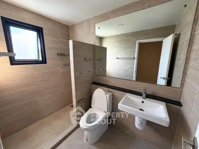 Modern bathroom with sleek fixtures and large mirror in a contemporary home.