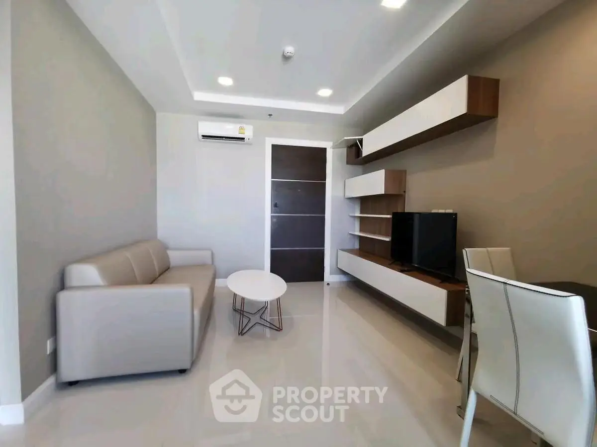 Modern living room with sleek furniture and wall-mounted TV in a stylish apartment.
